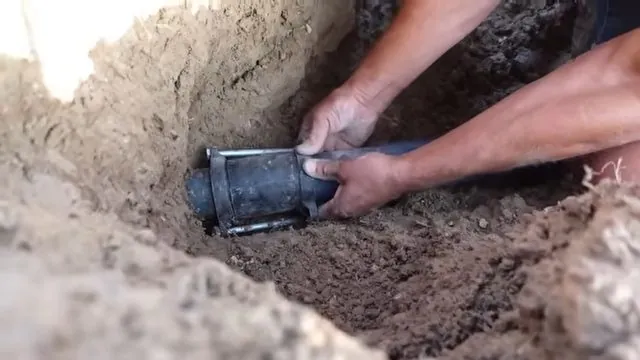 Plumber aligning a repair sleeve onto a water pipe