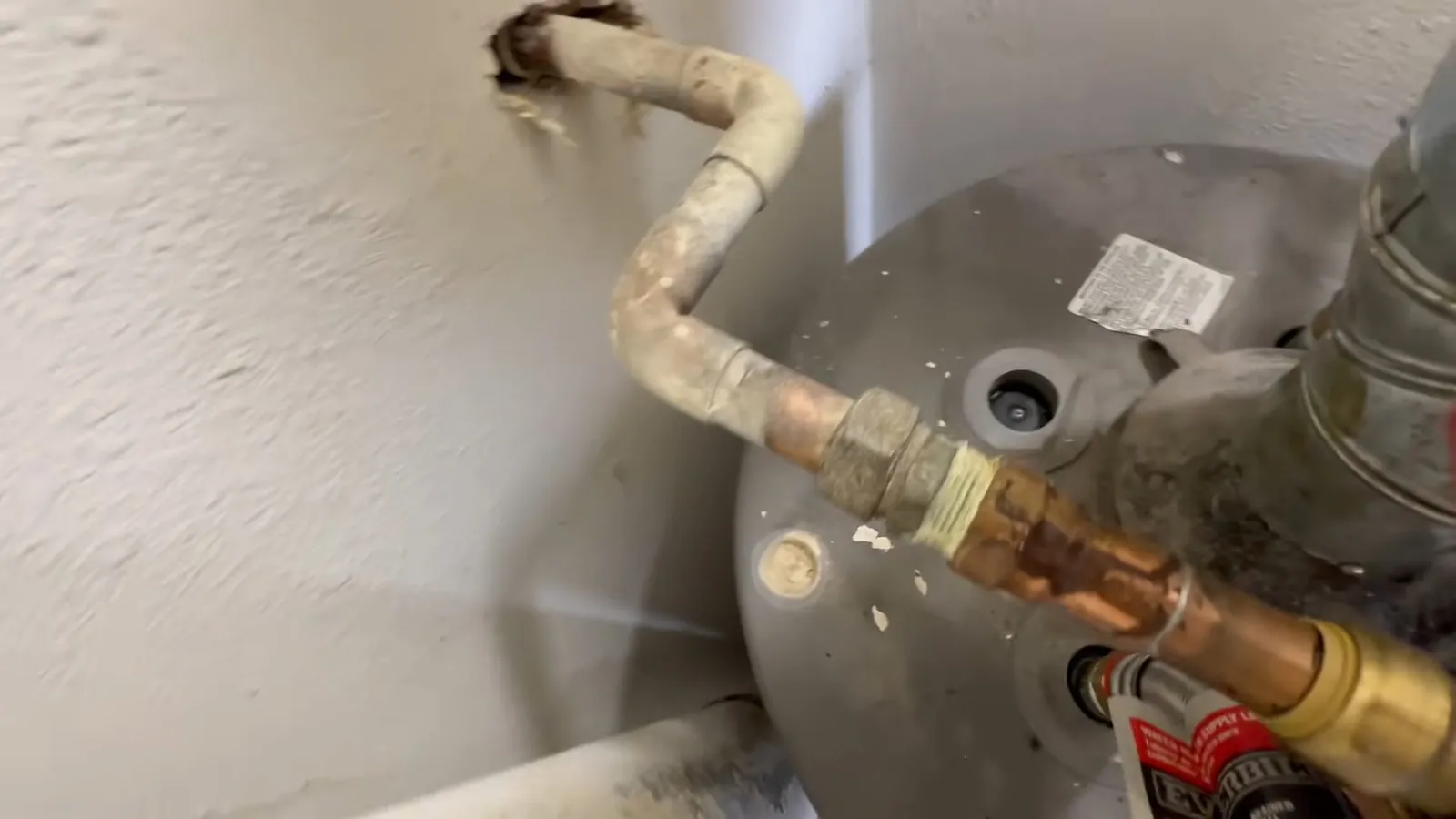 New anode rod being installed in a water heater tank
