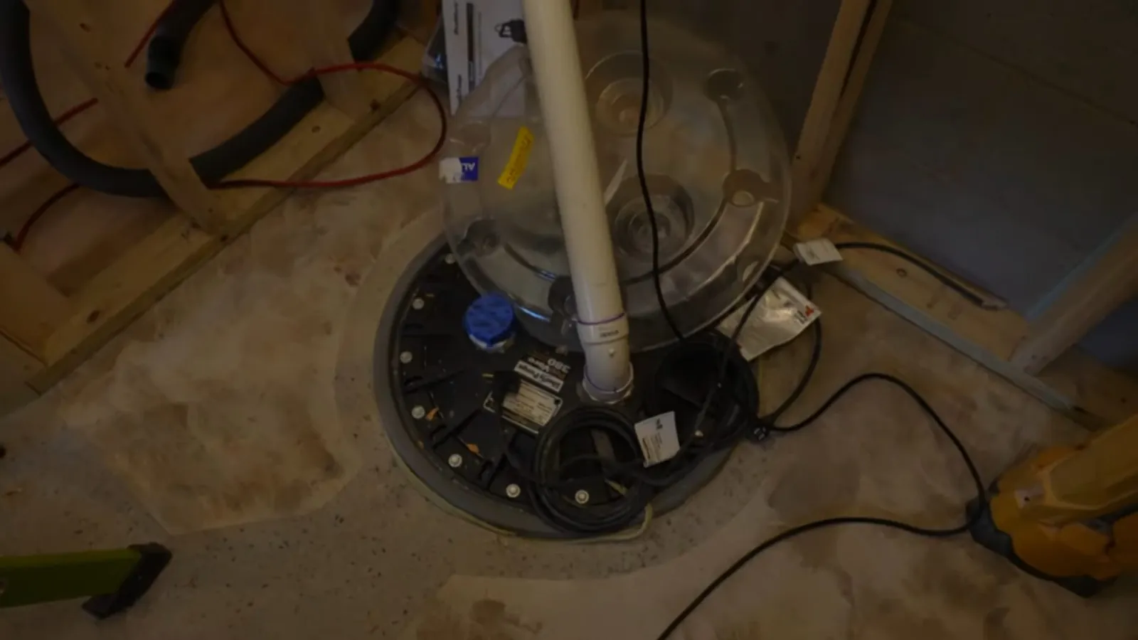 Section of basement floor drain pipe exposed through a cut-out