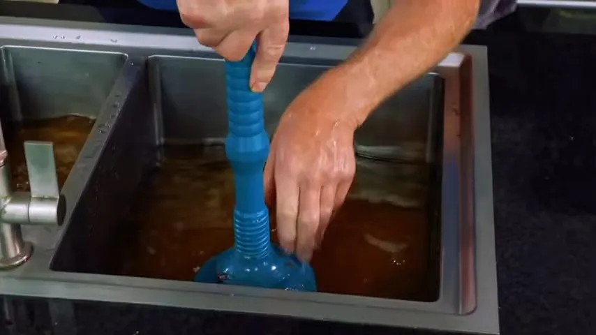 Clogged kitchen drain seen through the sink strainer