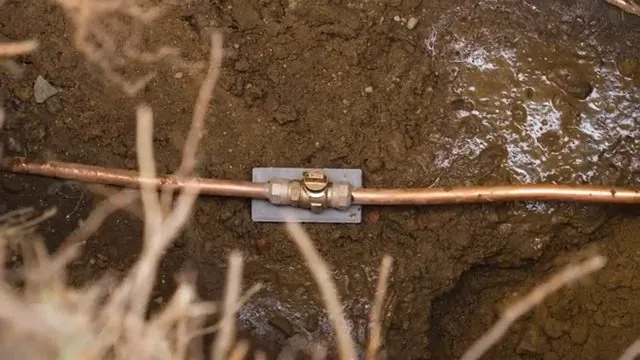 Plumber connecting a new copper service line indoors