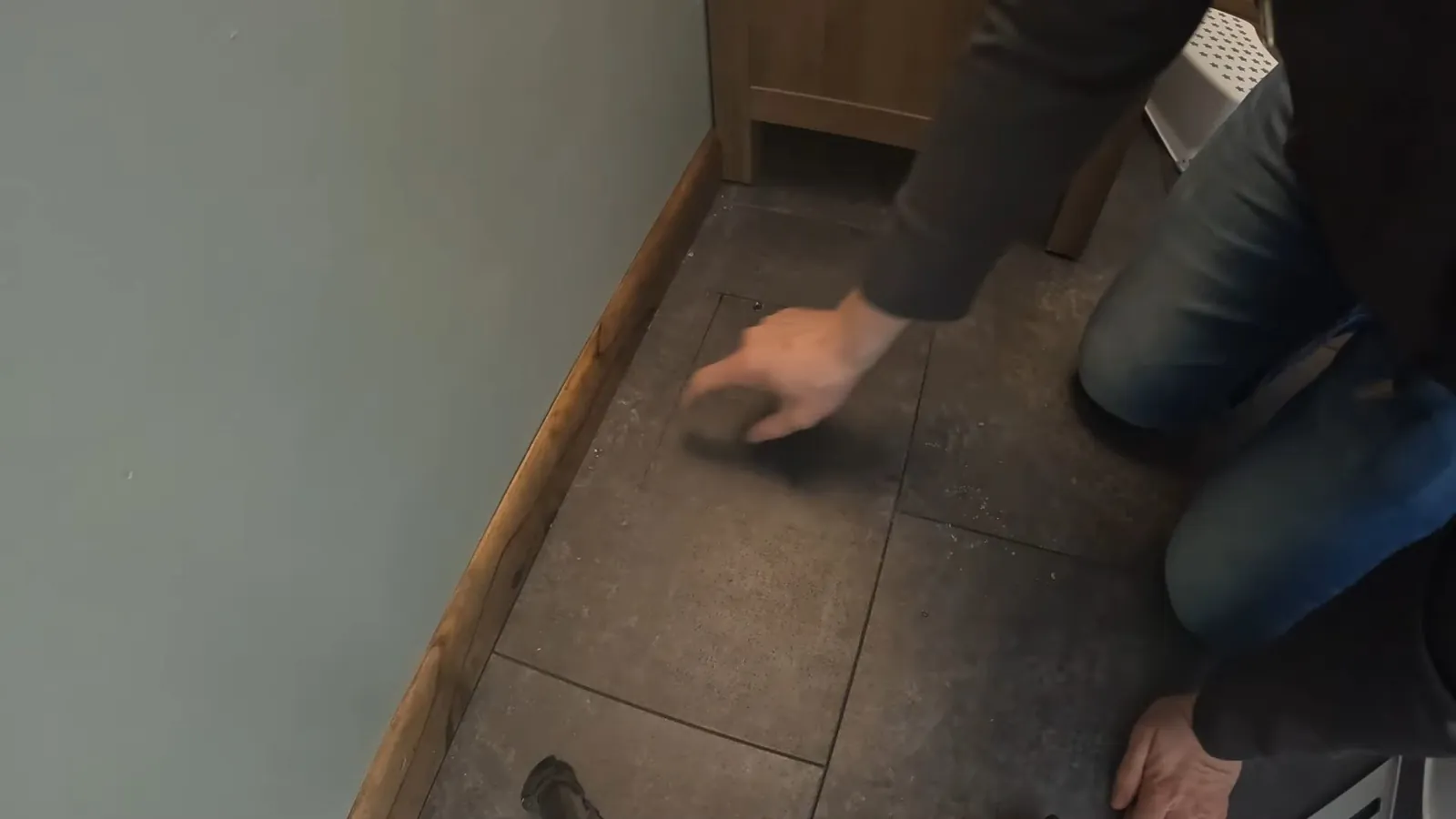 Contractor measuring a bathroom tile layout before work begins