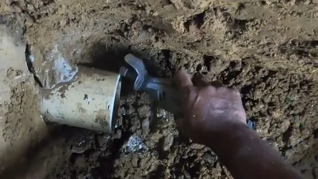 Damaged sewer pipe exposed and cut during excavation