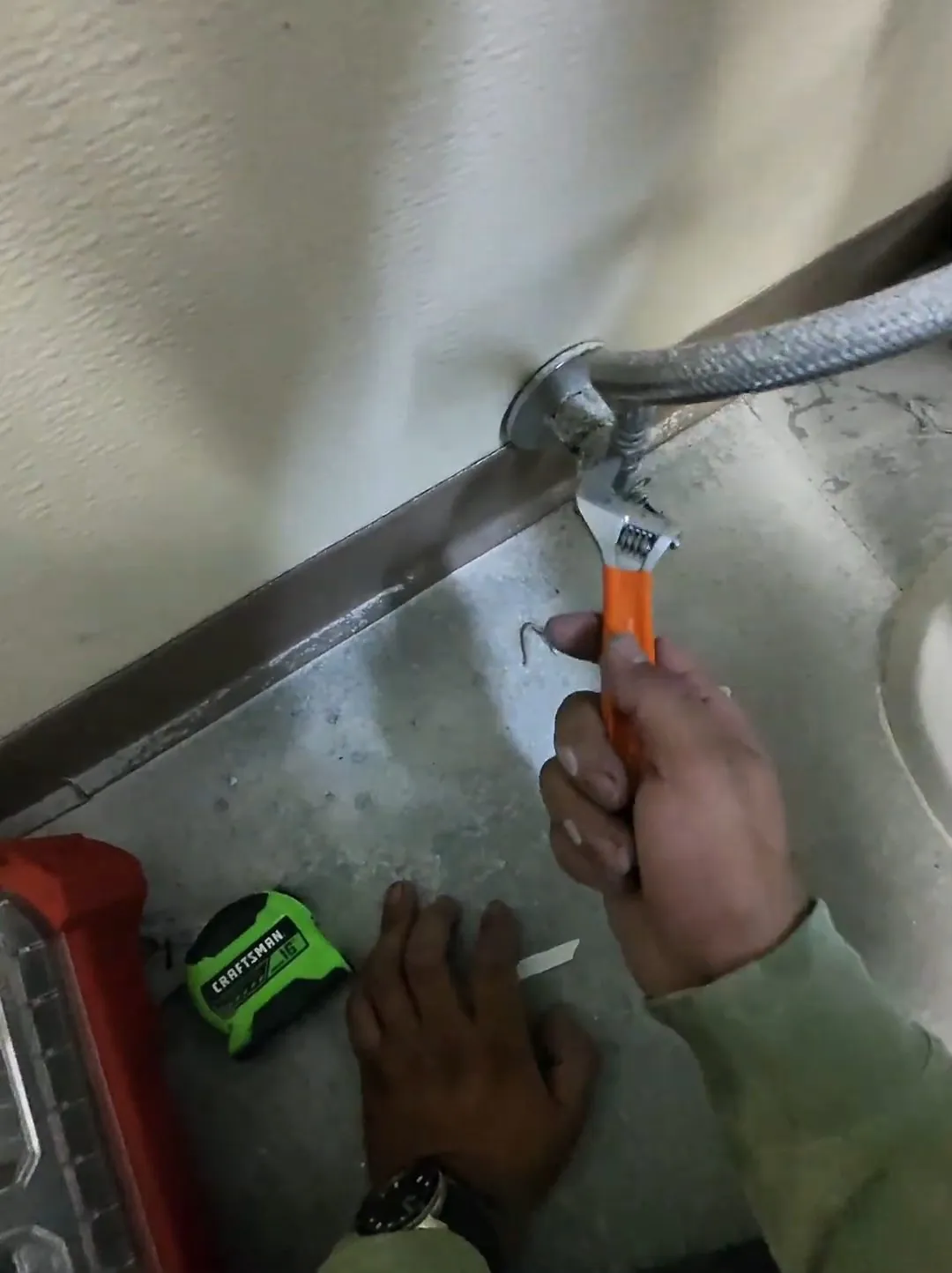 Commercial bathroom wall drain being installed