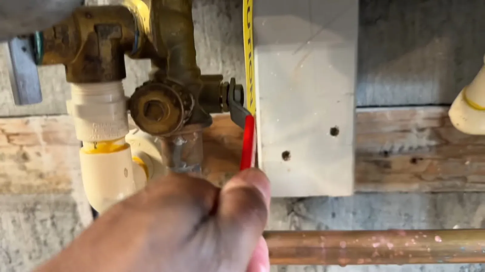 Technician opening a tankless water heater's service valve
