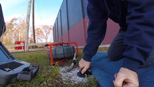 Technician feeding a camera into a main sewer line