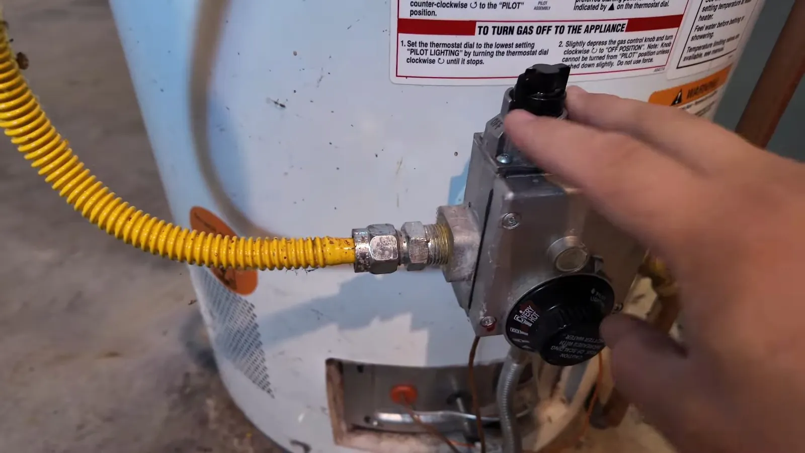 Technician using a handheld gas detector near a gas line fitting