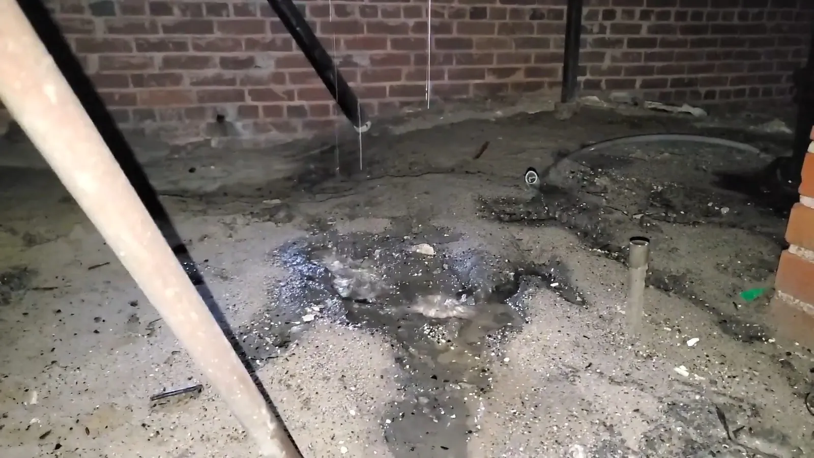 Wet ground beneath a leaking crawlspace pipe