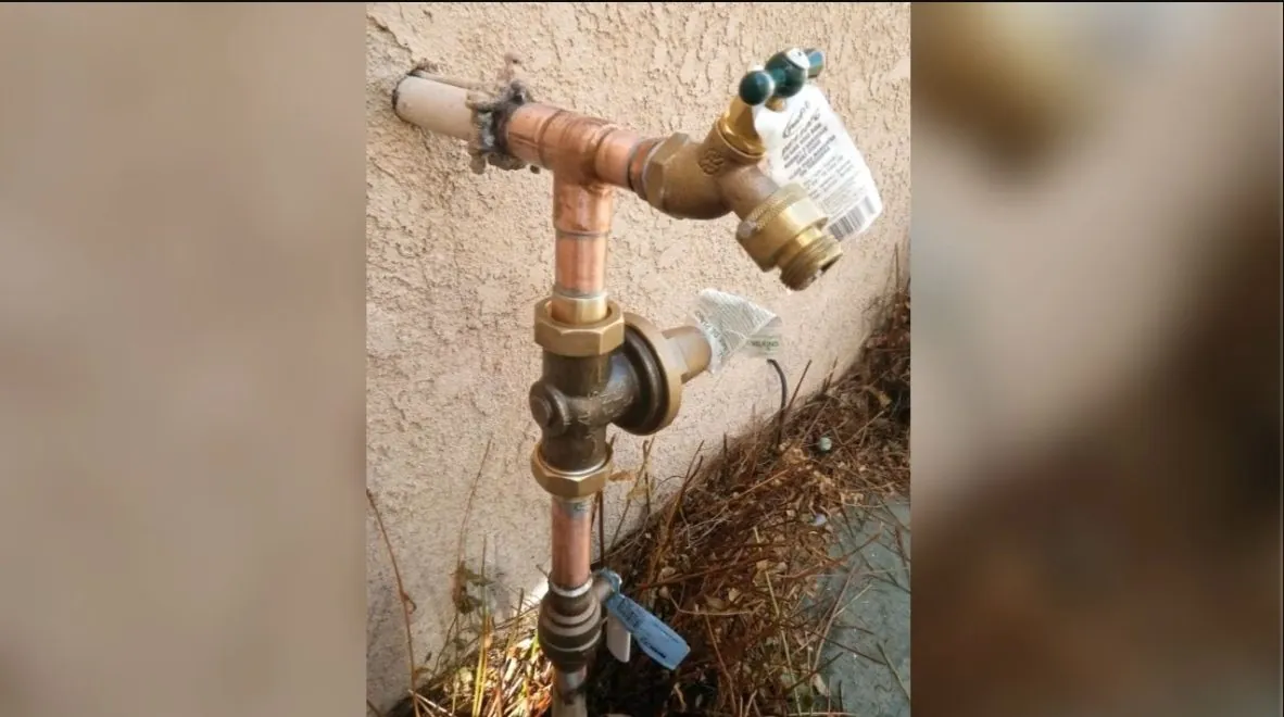 Worker opening a water heater's shutoff valve