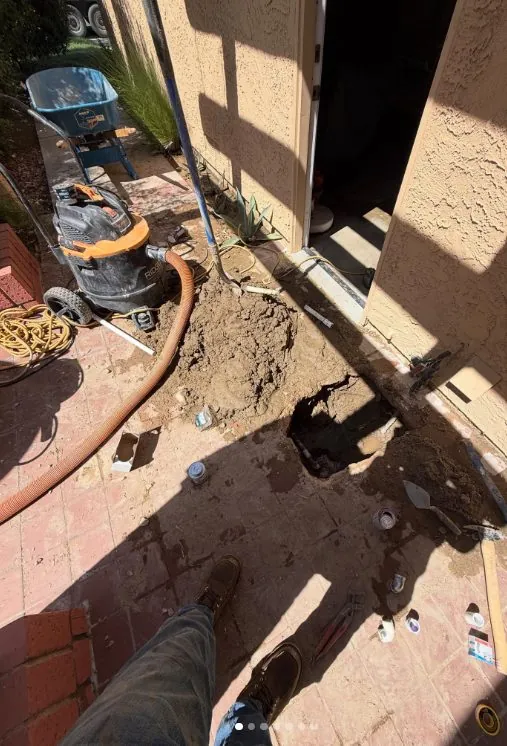 Worker saw-cutting a concrete slab for repair access
